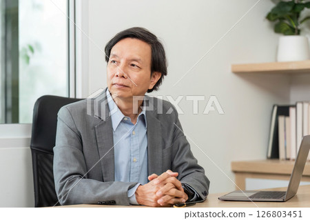 Business Professional in Meeting. A focused businessman discussing financial reports in a modern office. 126803451