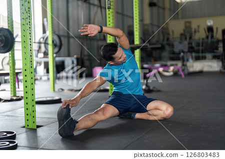 Fitness and Flexibility. Man stretching his side in a gym for improved mobility. 126803483
