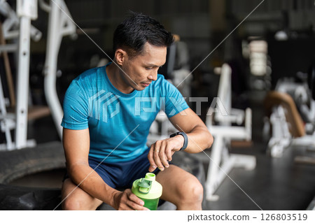 Fitness Enthusiast Checking Smartwatch During Workout Break 126803519