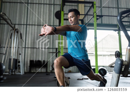 Fitness Training. Male athlete performing lunge exercise in gym. Fitness Training. Male athlete performing lunge exercise in gym. 126803559
