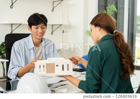 ESG and Innovation. Young architects presenting sustainable building model. 126803619