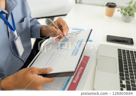Accounting Professional Analyzing Financial Data with Laptop and Charts Accounting Professional Analyzing Financial Data with Laptop and Charts 126803684