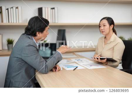 Professional Discussion and Strategy Planning. Business partners engaging in a meeting about financial goals. Professional Discussion and Strategy Planning. Business partners engaging in a meeting about financial goals. 126803695