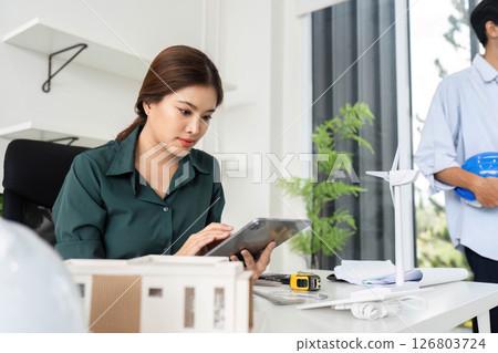 Sustainability in Architecture. Female engineer using tablet for eco-friendly project planning. 126803724