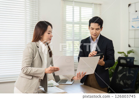 Business Collaboration and Strategy. Professionals discussing project documents in modern office. Business Collaboration and Strategy. Professionals discussing project documents in modern office. 126803745