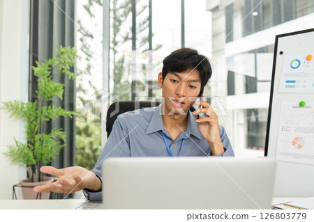 Young Professional Expressing Ideas During Phone Call in Modern Office 126803779