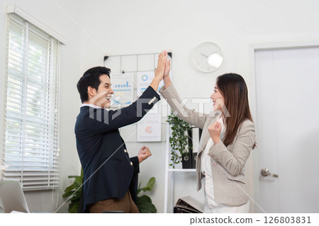 Professional Collaboration and Success. Two colleagues celebrating a business achievement with high fives. 126803831