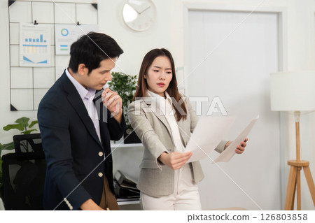 Business Collaboration and Strategy. Professionals discussing project documents in modern office. 126803858