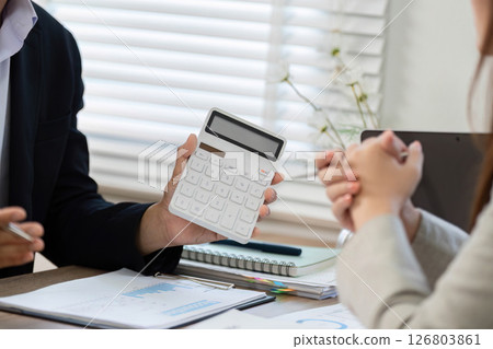Financial Consultation with Calculator. Businessman explaining financial data to a client. 126803861