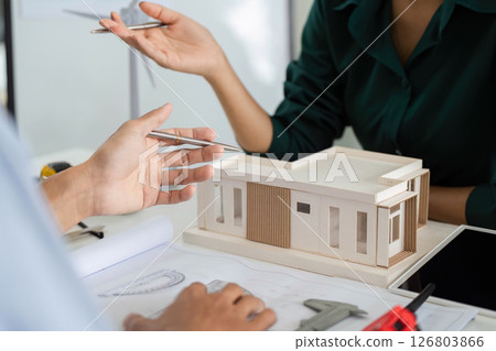Sustainability in Architecture. Professionals discussing a model building with ESG focus. Sustainability in Architecture. Professionals discussing a model building with ESG focus. 126803866