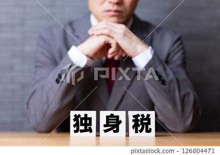 一位穿著西裝的中年男性商人擔心單一稅收障礙 一位穿著西裝的中年男性商人擔心單一稅收障礙 126804471
