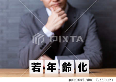 A middle-aged male businessman worried about the younger generation block and wearing a suit 126804764