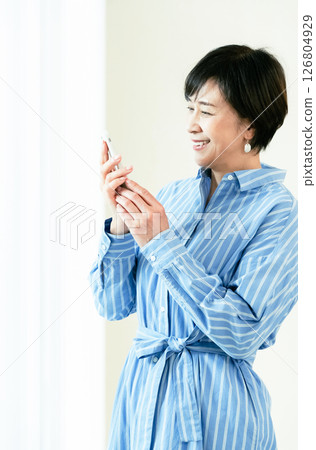 A middle-aged woman who operates a smartphone A middle-aged woman who operates a smartphone 126804929