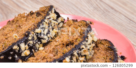 Pastry made of zucchini with nuts and raisin on wooden board. Delicious dessert 126805299