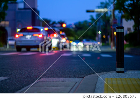 Sidewalk car stoppers and a crowded intersection at night - bollards 126805575