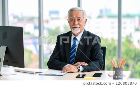 Senior Asian male businessman in a suit sitting at a desk 126805870