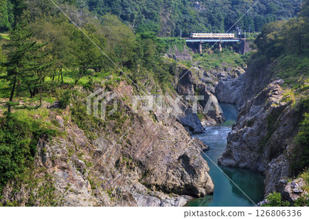 The Takayama Main Line runs through the Hisuikyo Gorge, which is filled with emerald-colored water. 126806336
