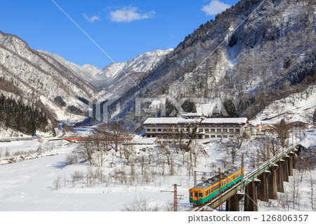 富山地方鐵道的列車從積雪的立山出發，穿過馬川橋 126806357
