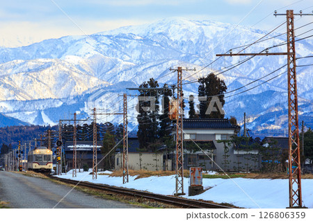 The majestic snow-covered Tateyama mountain range looms over the Toyama Chiho Railway as it enters Tsukioka Station. The majestic snow-covered Tateyama mountain range looms over the Toyama Chiho Railway as it enters Tsukioka Station. 126806359