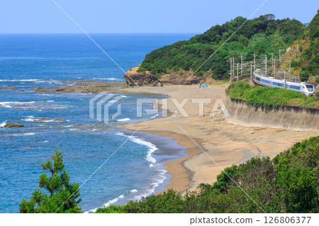 A limited express train on the Kisei Main Line races along the coastline near the southernmost tip of Honshu. 126806377