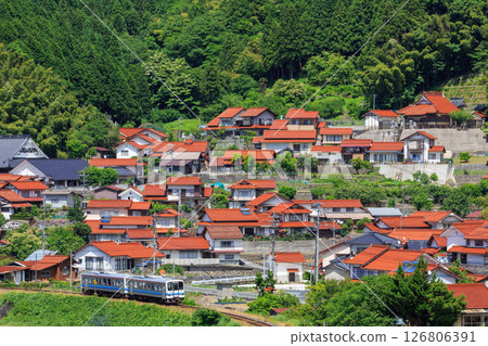 A Sanko Line diesel train running through streets paved with red Sekishu tiles 126806391