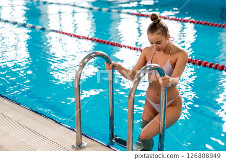 Fit Girl Stepping into Indoor Pool Fit Girl Stepping into Indoor Pool 126808949