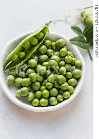 Close-up fresh green peas beans in a white plate. Macro photography 126810781