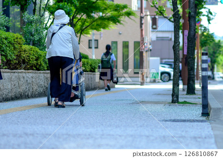 Senior woman pushing a wheelchair 126810867