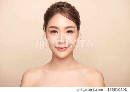 A beautiful young Asian woman with clean, fresh skin against a beige background. Skincare, facial treatment, cosmetology, beauty, and spa. An elegant portrait of an Asian woman. A beautiful young Asian woman with clean, fresh skin against a beige background. Skincare, facial treatment, cosmetology, beauty, and spa. An elegant portrait of an Asian woman. 126810898