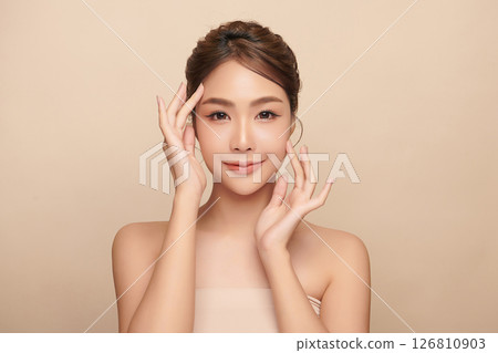 A beautiful young Asian woman with clean, fresh skin against a beige background. Skincare, facial treatment, cosmetology, beauty, and spa. An elegant portrait of an Asian woman. A beautiful young Asian woman with clean, fresh skin against a beige background. Skincare, facial treatment, cosmetology, beauty, and spa. An elegant portrait of an Asian woman. 126810903