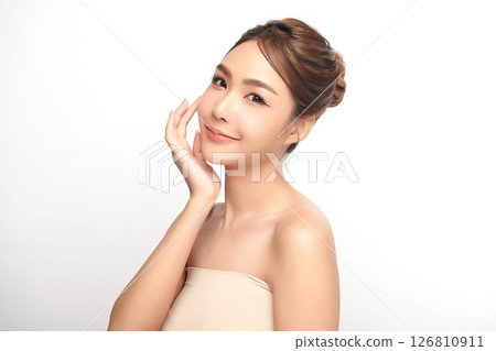 A beautiful young Asian woman with clean, fresh skin against a white background. Skincare, facial treatment, cosmetology, beauty, and spa. An elegant portrait of an Asian woman. 126810911