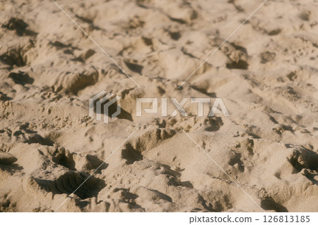 chain of footprints in the sand. The footprints of human shoes are arranged in row and very close. chain of footprints in the sand. The footprints of human shoes are arranged in row and very close. 126813185