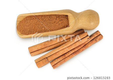 Cinnamon sticks with powder in wooden scoop isolated on white background. Top view. Flat lay. Cinnamon sticks with powder in wooden scoop isolated on white background. Top view. Flat lay. 126813283