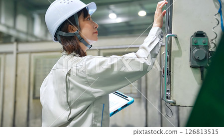 一名女工用平板電腦檢查工廠機器 126813515