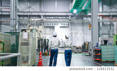 Rear view of a group of workers working in a factory Rear view of a group of workers working in a factory 126813532
