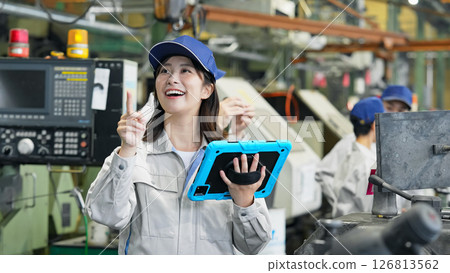 A group of workers inspecting a machine using a tablet PC 126813562