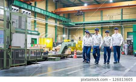 A group of workers walking side by side in a factory 126813605