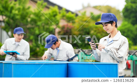 A group of workers inspecting drums A group of workers inspecting drums 126813620
