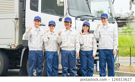 A group of workers pumping their fists in front of a truck A group of workers pumping their fists in front of a truck 126813627