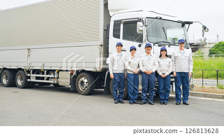 A group of workers lined up in front of a truck A group of workers lined up in front of a truck 126813628