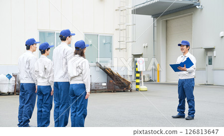 A group of workers meeting in front of a factory 126813647