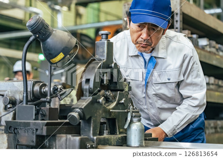 Male worker operating a machine in a factory Male worker operating a machine in a factory 126813654