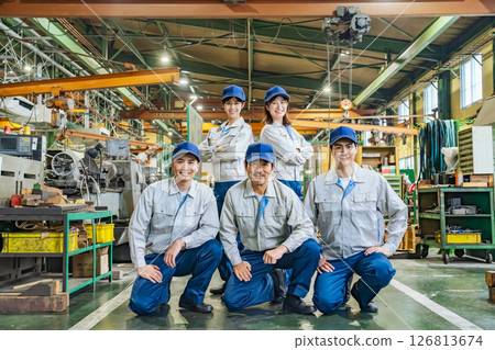 A group of workers lined up in a factory 126813674