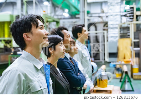 A group of workers standing in a factory 126813676