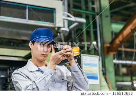 Male worker inspecting products at a factory 126813682