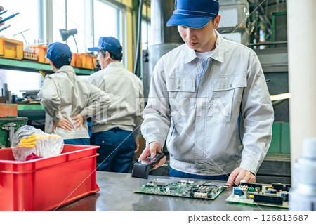一名男工人在工廠使用手持終端檢查產品 126813687