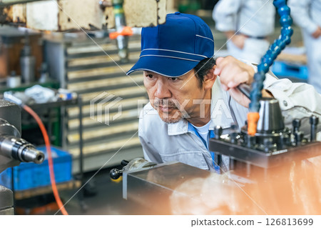 一名男工人在工廠操作機器 一名男工人在工廠操作機器 126813699