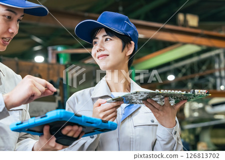 Male and female workers inspecting products using a tablet in a factory Male and female workers inspecting products using a tablet in a factory 126813702