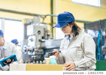 工廠裡一群女工使用手持終端管理產品 工廠裡一群女工使用手持終端管理產品 126813705