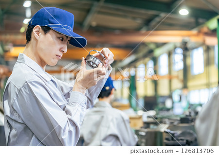 Male worker inspecting products at a factory 126813706